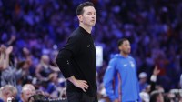 Lakers head coach JJ Redick watches his team play against the Oklahoma City Thunder during the second half at Paycom Center with Fox Sports 1's Colin Cowherd in the background