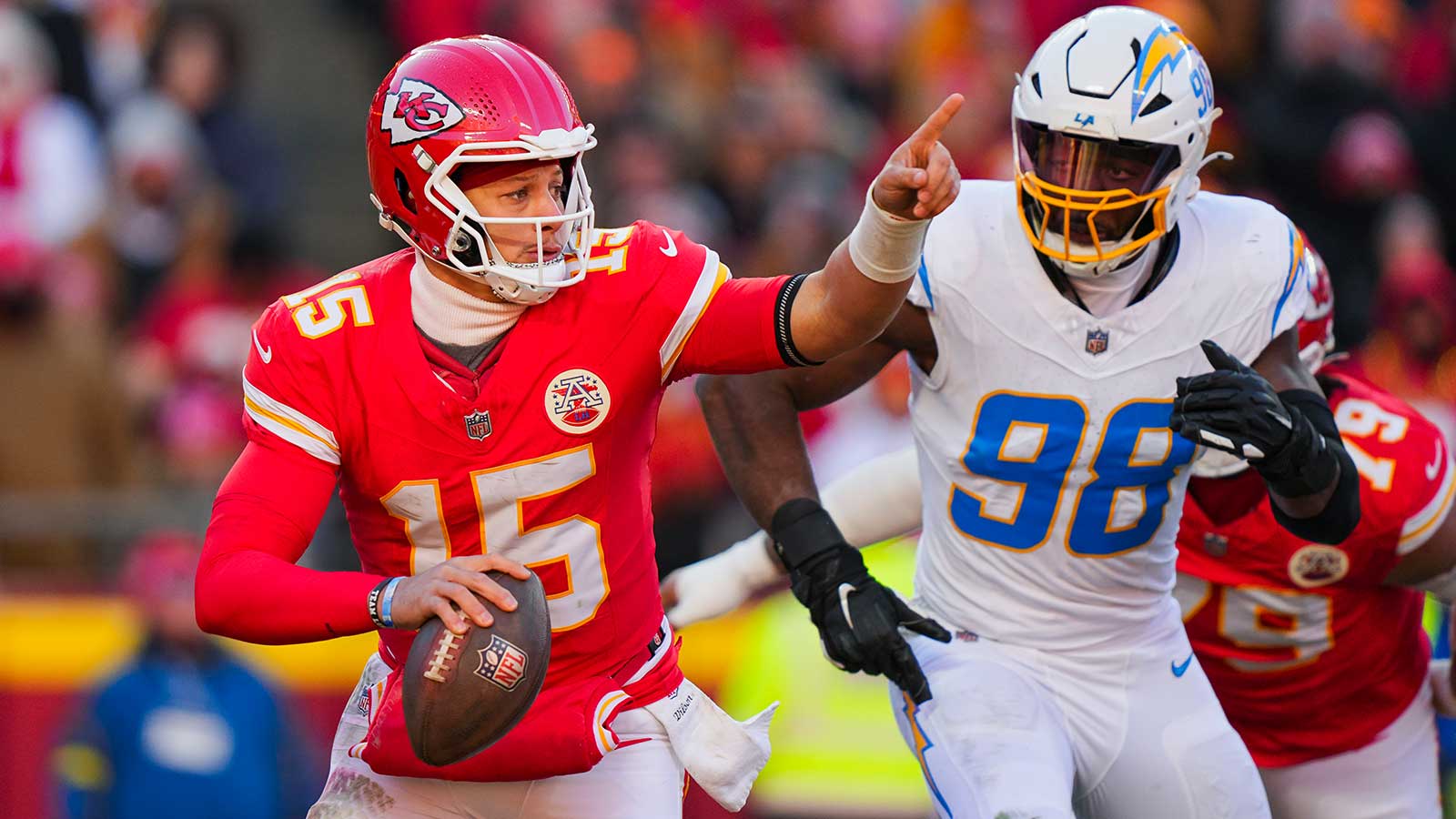Kansas City Chiefs quarterback Patrick Mahomes (15) scrambles against Los Angeles Chargers linebacker Odafe Oweh (98) during the second half at GEHA Field at Arrowhead Stadium.