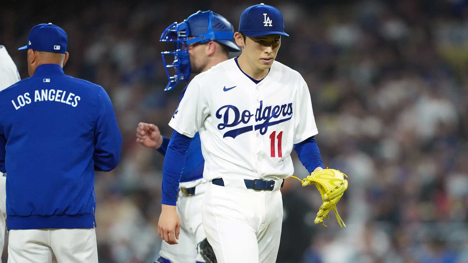 Los Angeles Dodgers pitcher Roki Sasaki (11) walks back to the dugout as he is taken out from the game by manager Dave Roberts (left) during the fifth inning against the Cleveland Guardians at Dodger Stadium. Mandatory Credit: Kirby Lee-Imagn Images