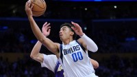 Mavericks guard Max Christie (00) drives past Los Angeles Lakers center Jaxson Hayes (11) in the second half at Crypto.com Arena with Lakers' Luka Doncic in the background