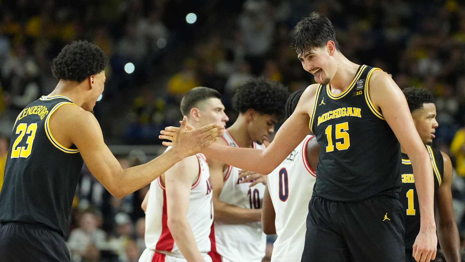 Michigan Wolverines center Aday Mara (15) and Michigan Wolverines forward Yaxel Lendeborg (23) react against the Arizona Wildcats in the second half during a semifinal of the Final Four of the men's 2026 NCAA Tournament at Lucas Oil Stadium.