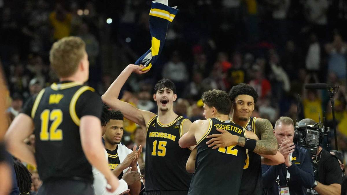 Michigan Wolverines players celebrate after defeating the Arizona Wildcats during a semifinal of the Final Four of the men's 2026 NCAA Tournament at Lucas Oil Stadium.