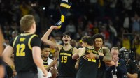 Michigan Wolverines players celebrate after defeating the Arizona Wildcats during a semifinal of the Final Four of the men's 2026 NCAA Tournament at Lucas Oil Stadium.