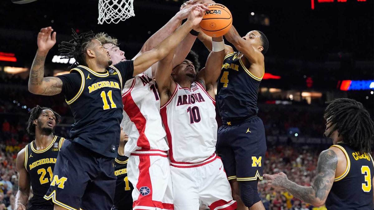 Michigan guard Nimari Burnett (4), Arizona center Motiejus Krivas (13), Arizona forward Koa Peat (10) and Michigan guard Nimari Burnett (4) reach for the ball in the first half of their Final Four game at Lucas Oil Stadium in Indianapolis on Saturday, April 4, 2026.