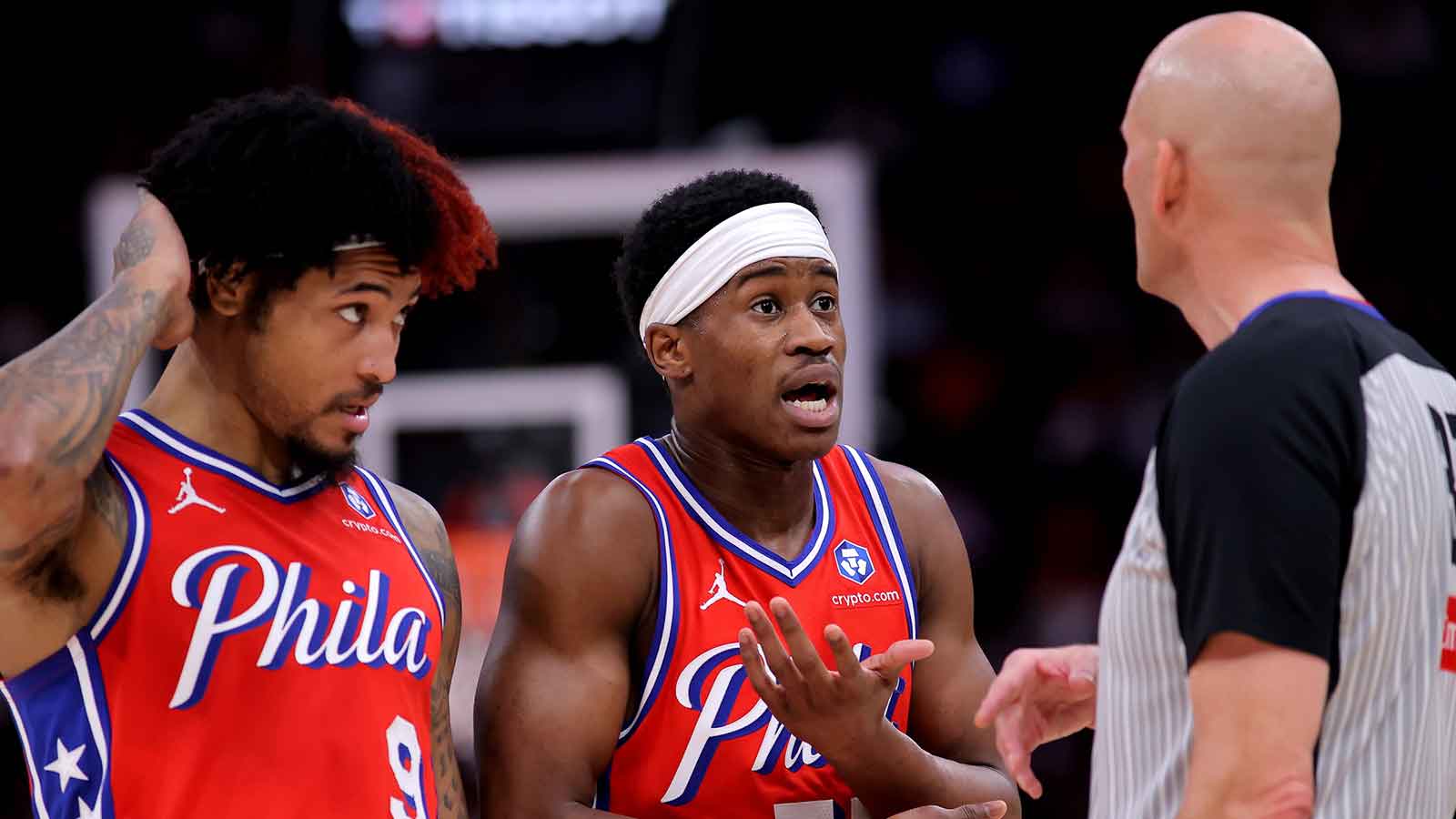 Philadelphia 76ers guard VJ Edgecombe (77) and forward Kelly Oubre Jr. (9) talk with NBA referee Eric Dalen (37) during the second quarter against the Houston Rockets at Toyota Center.
