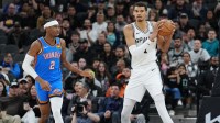 Spurs center Victor Wembanyama (1) looks down the court beside Oklahoma City Thunder guard Shai Gilgeous-Alexander (2) in the first half at Frost Bank Center with Warriors' Draymond Green in the background