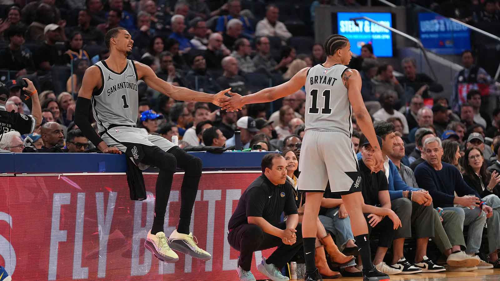 San Antonio Spurs center Victor Wembanyama (1) waits to check into the game next to forward Carter Bryant (11) during a break in the action against the Golden State Warriors in the second quarter at the Chase Center.
