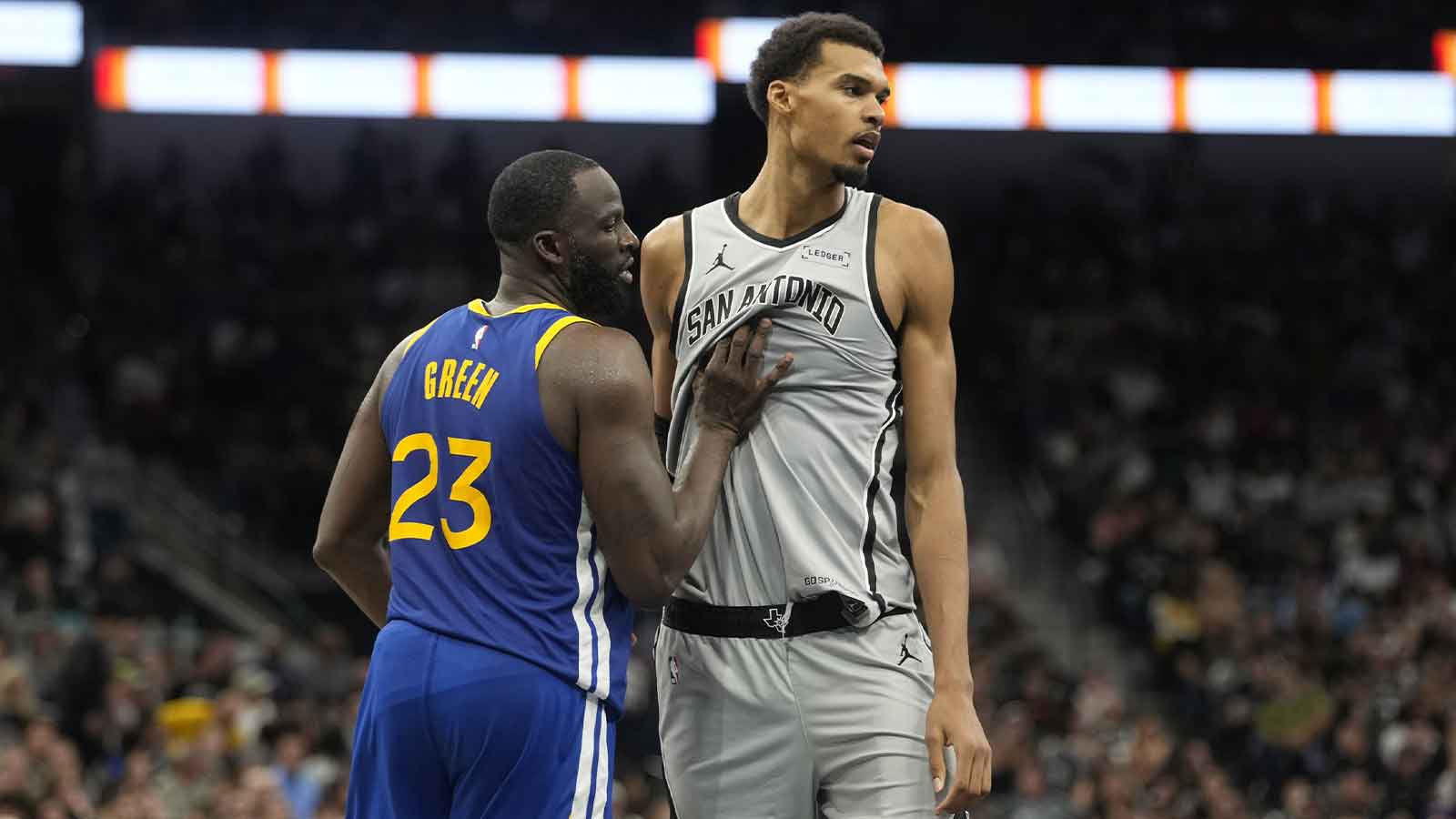 Spurs forward Victor Wembanyama (1) waits for an inbound pass while defended by Golden State Warriors forward Draymond Green (23) during the second half at Frost Bank Center