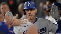Los Angeles Dodgers first baseman Freddie Freeman (5) is greeted in the dugout after a solo home run in the ninth inning against the Cleveland Guardians at Dodger Stadium.
