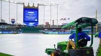 Apr 3, 2026; Kansas City, Missouri, USA; A general view as a grounds crew employee anchors down the tarp as the game between the Kansas City Royals and Milwaukee Brewers is postponed and will be played as part of a double-header on Saturday April 4th at Kauffman Stadium. Mandatory Credit: Denny Medley-Imagn Images