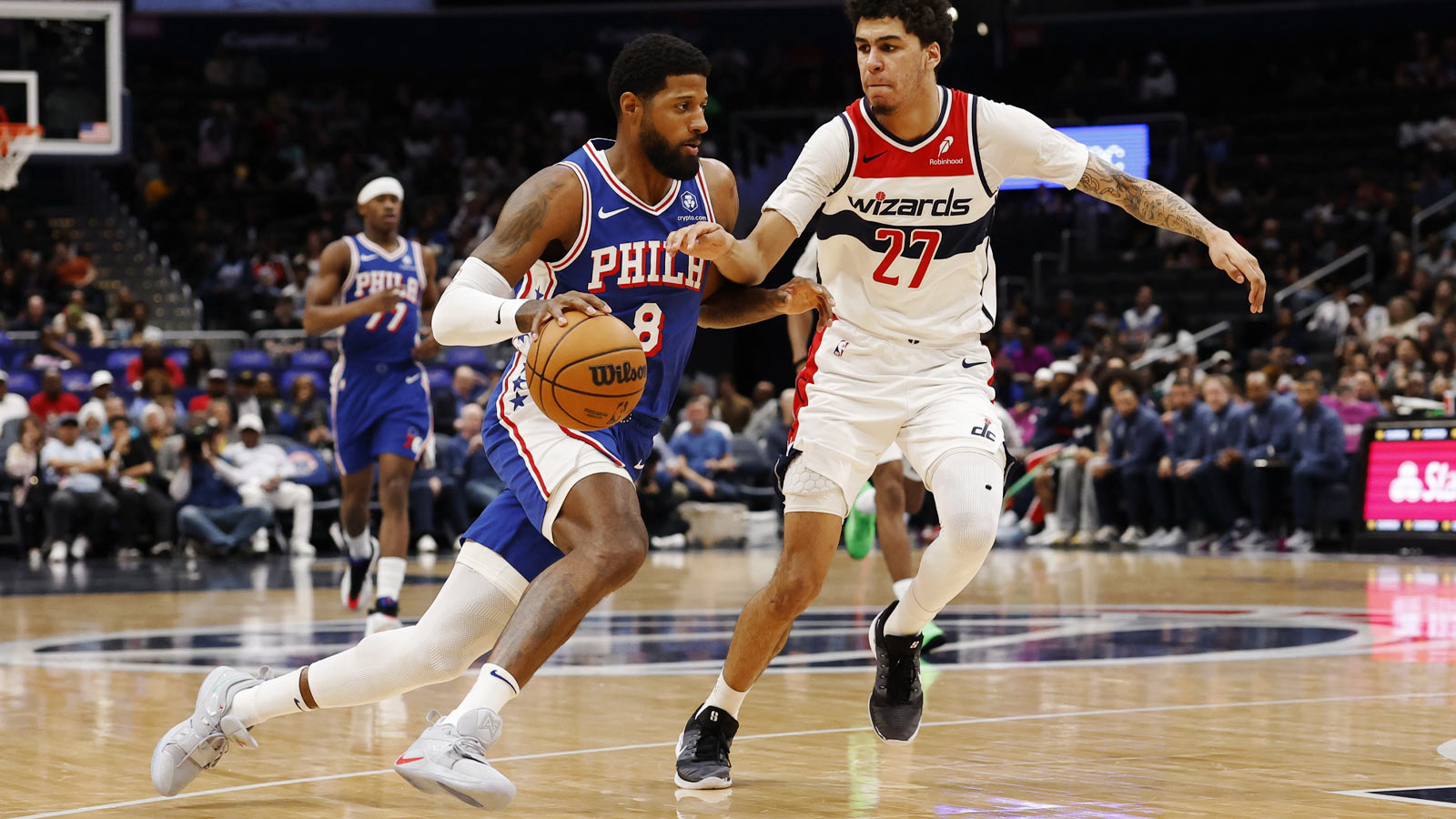 Philadelphia 76ers forward Paul George (8) drives to the basket as Washington Wizards guard Will Riley (27) defends in the first half at Capital One Arena.