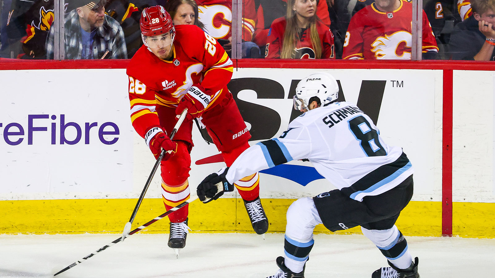 Calgary Flames defenseman Zach Whitecloud (28) controls the puck against Utah Mammoth center Nick Schmaltz (8) during the second period at Scotiabank Saddledome. 
