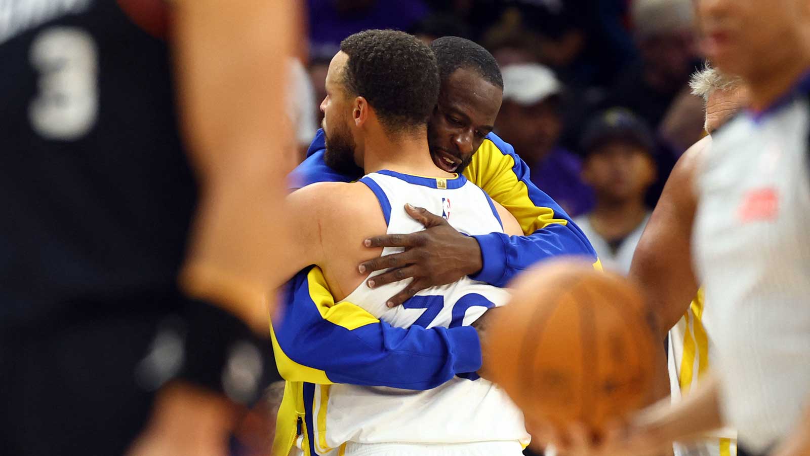 Golden State Warriors guard Stephen Curry (30) hugs forward Draymond Green against the Phoenix Suns during the closing seconds of the play-in rounds of the 2026 NBA Playoffs at Mortgage Matchup Center.