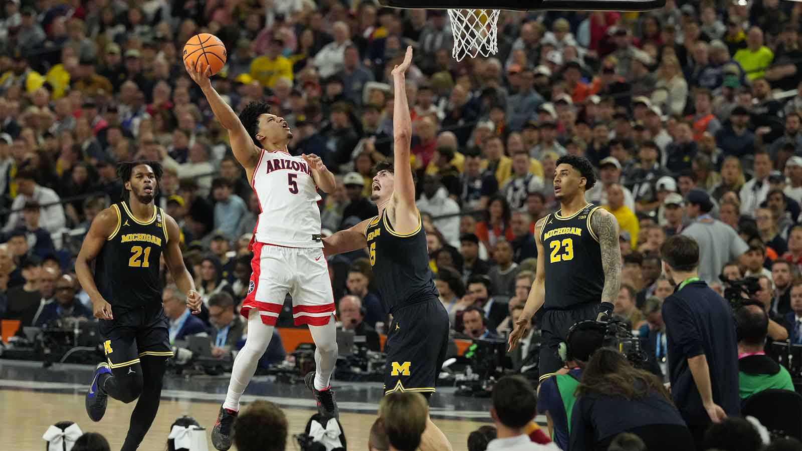 Arizona Wildcats guard Brayden Burries (5) shoots against Michigan Wolverines center Aday Mara (15) in the second half during a semifinal of the Final Four of the men's 2026 NCAA Tournament at Lucas Oil Stadium.