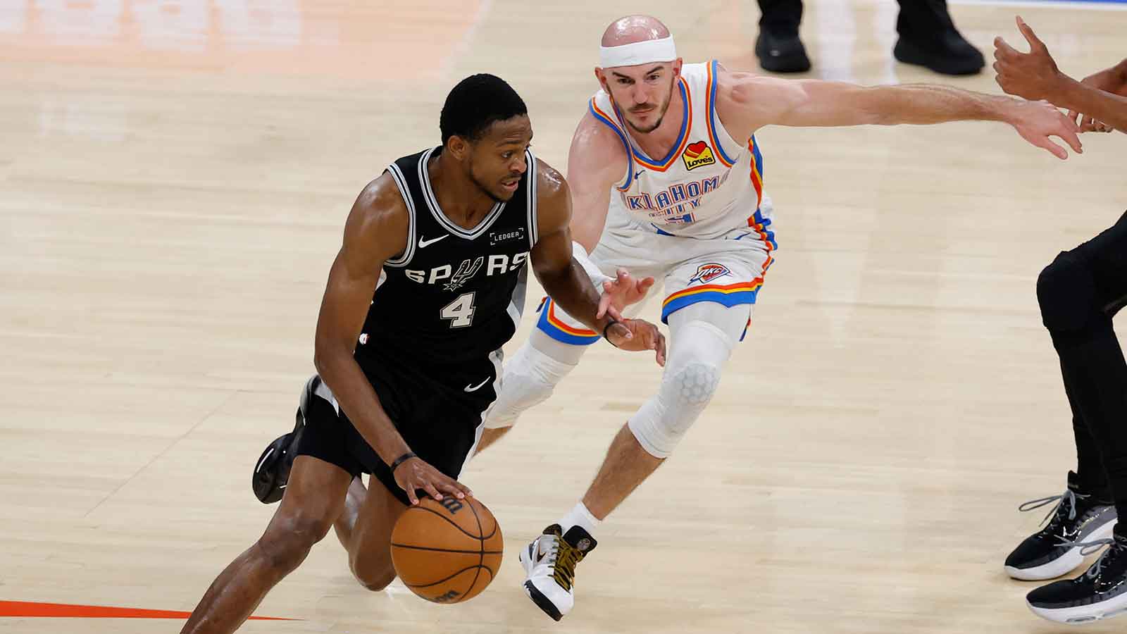 San Antonio Spurs guard De'aaron Fox (4) drives against Oklahoma City Thunder guard Alex Caruso (9) during the fourth quarter in game five of the western conference finals for the 2026 NBA playoffs at Paycom Center.
