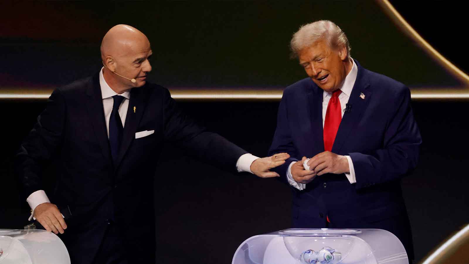 U.S. President Donald Trump (R) opens a draw ball as FIFA President Gianni Infantino (L) gestures during the FIFA World Cup 2026 Final Draw at John F. Kennedy Center for the Performing Arts.