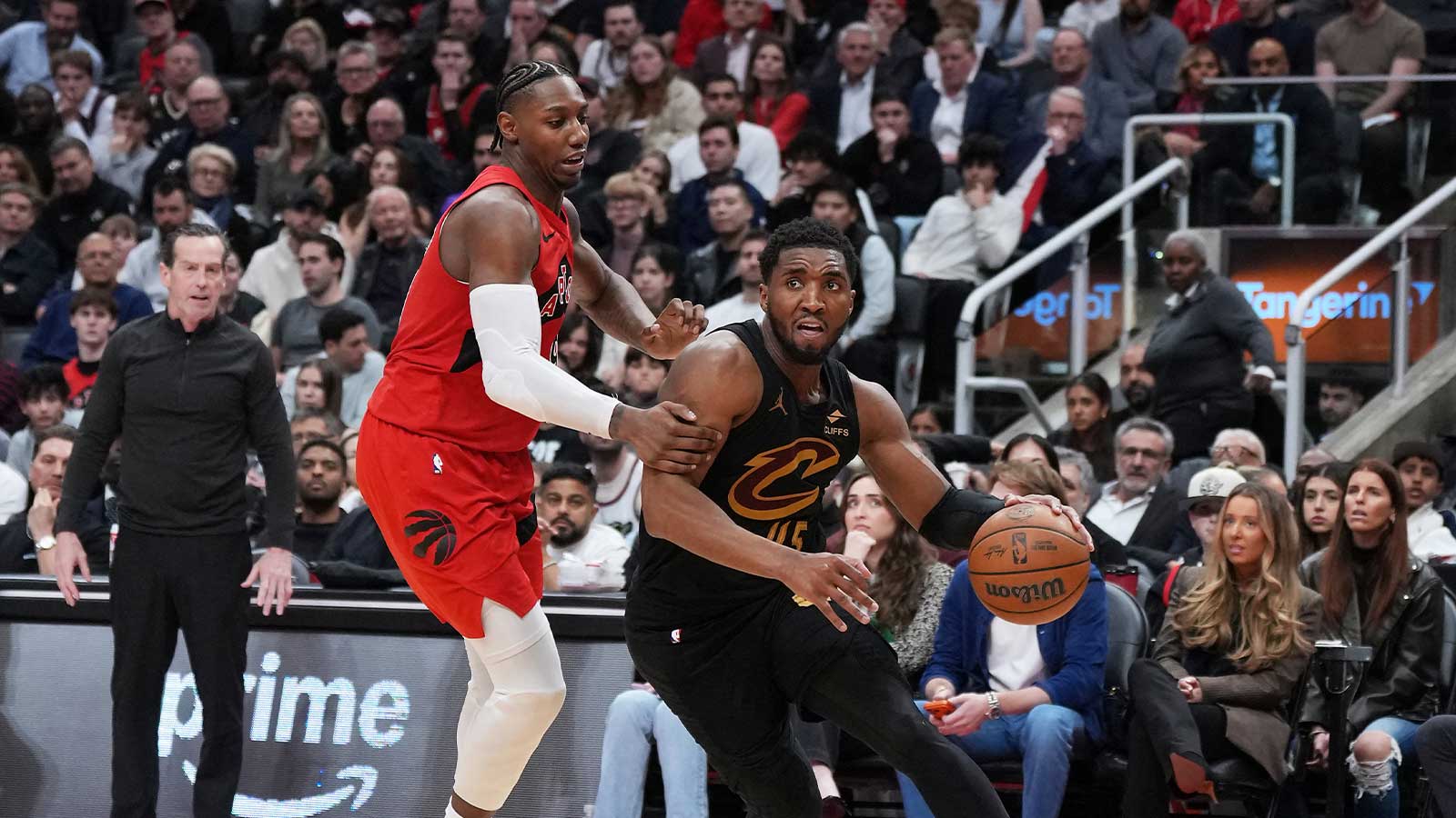Cleveland Cavaliers guard Donovan Mitchell (45) controls the ball as Toronto Raptors forward RJ Barrett (9) tries to defend during the overtime period in game six of the first round of the 2026 NBA Playoffs at Scotiabank Arena. 