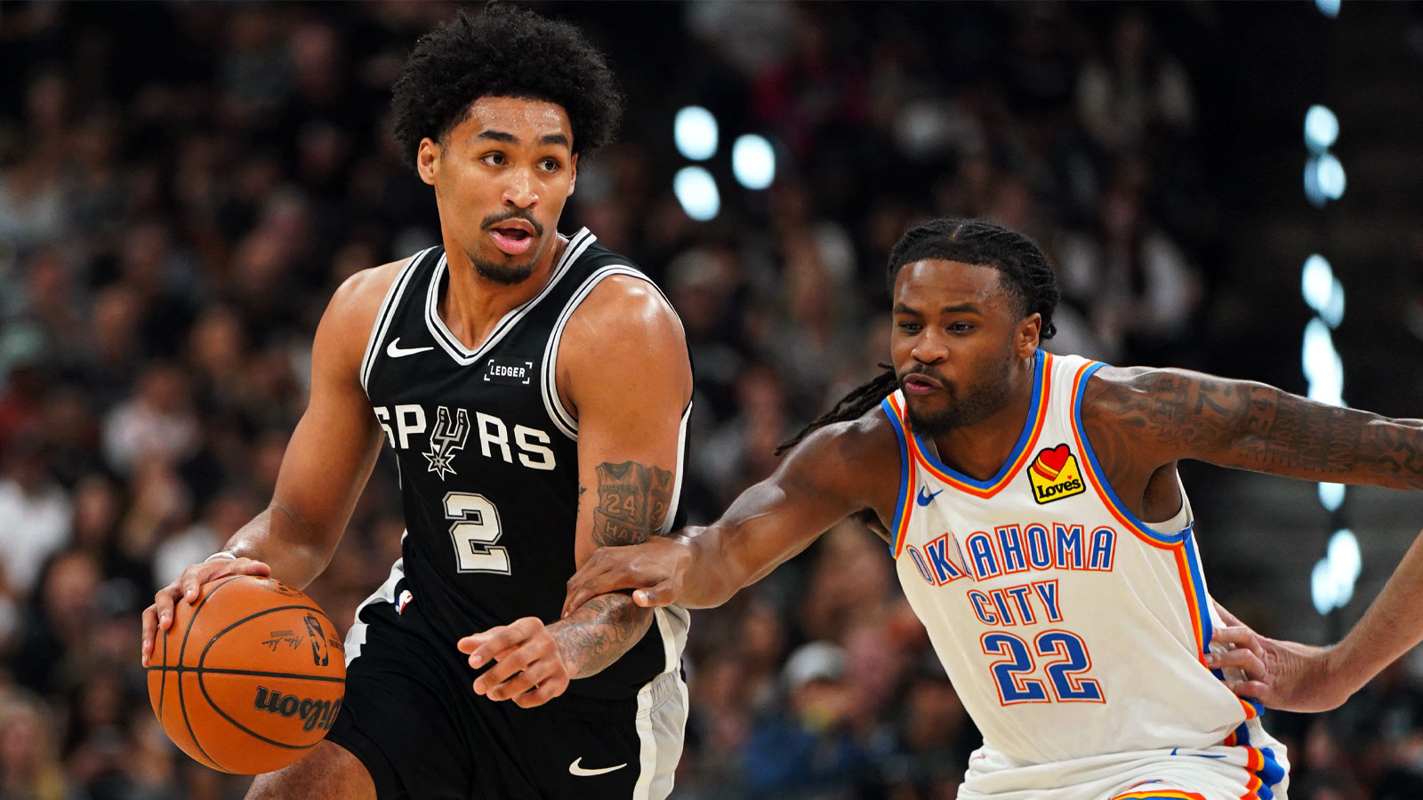San Antonio Spurs guard Dylan Harper (2) dribbles the ball past Oklahoma City Thunder guard Cason Wallace (22) in the first half during game six of the western conference finals for the 2026 NBA playoffs at Frost Bank Center. 