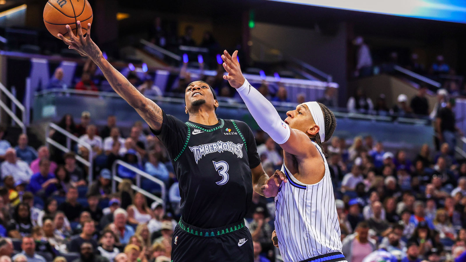 Minnesota Timberwolves forward Jaden McDaniels (3) lays up in front of Orlando Magic forward Paolo Banchero (5) during the first quarter at Kia Center.
