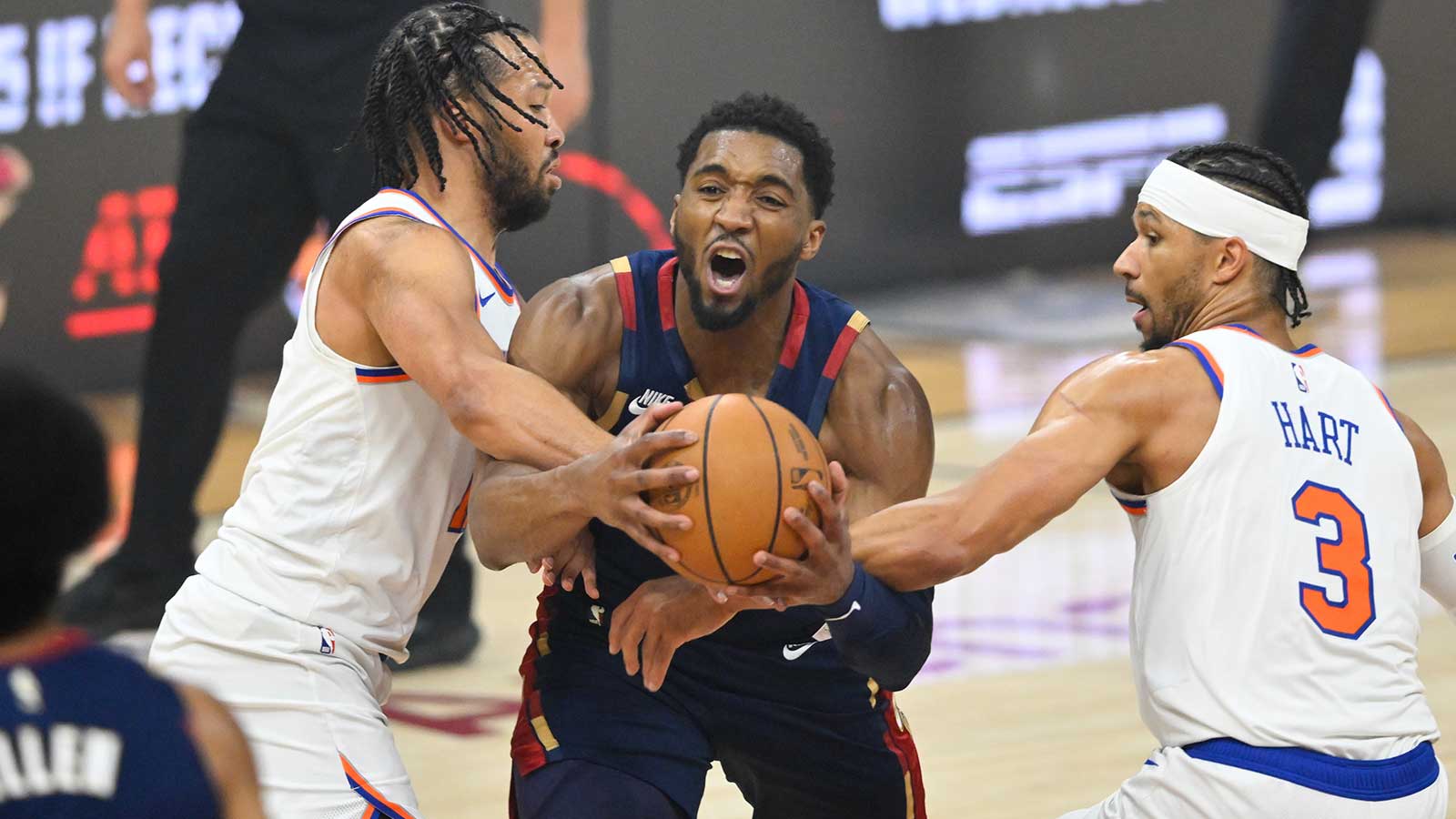 Cleveland Cavaliers guard Donovan Mitchell (45) drives the ball while defended by New York Knicks guard Jalen Brunson (11) and forward Josh Hart (3) in the first quarter during game four of the eastern conference finals for the 2026 NBA playoffs at Rocket Arena.