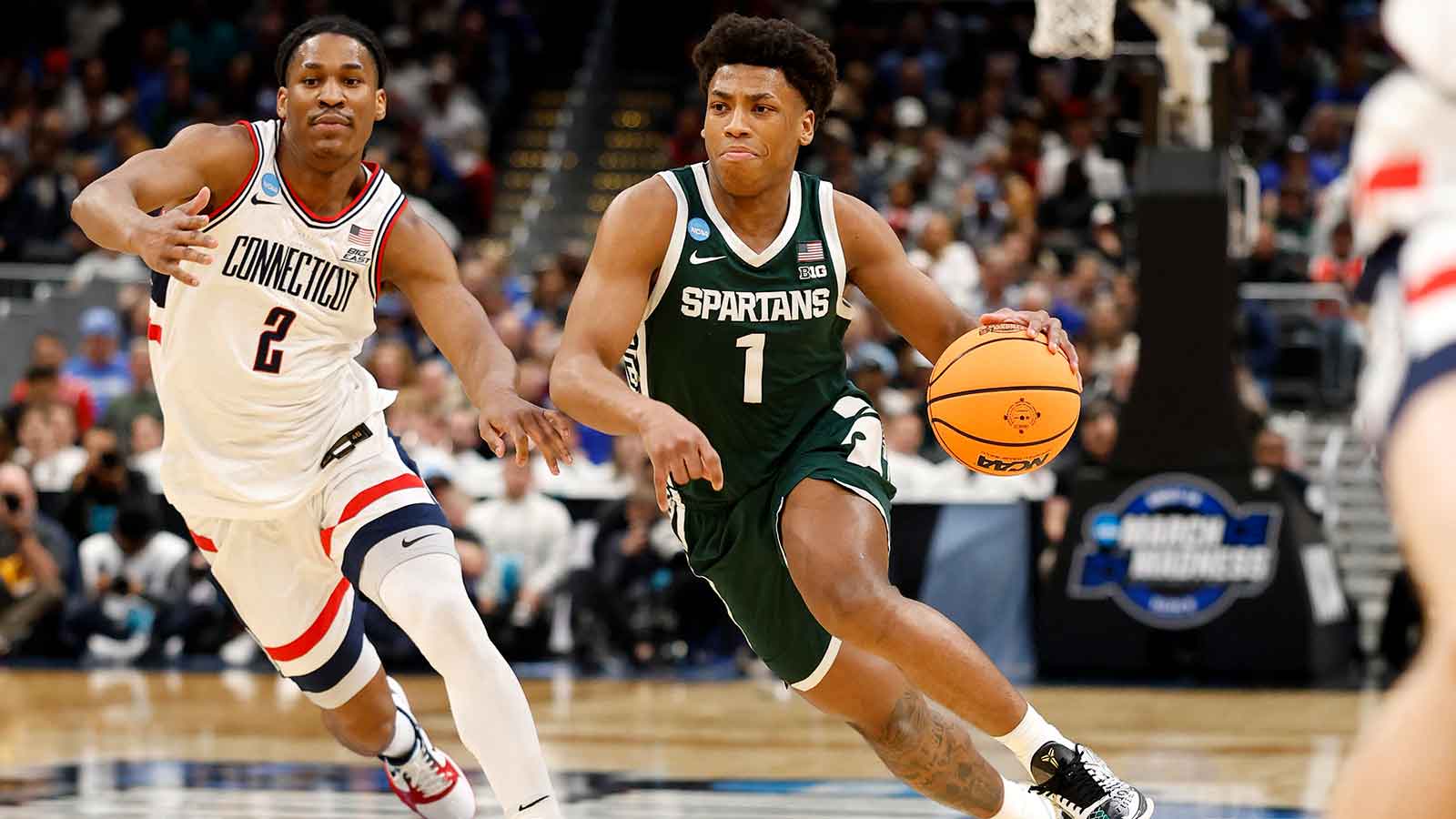 Michigan State Spartans guard Jeremy Fears Jr. (1) dribbles the ball past UConn Huskies guard Silas Demary Jr. (2) in the first half during a Sweet Sixteen game of the East Regional of the men's 2026 NCAA Tournament at Capital One Arena. 
