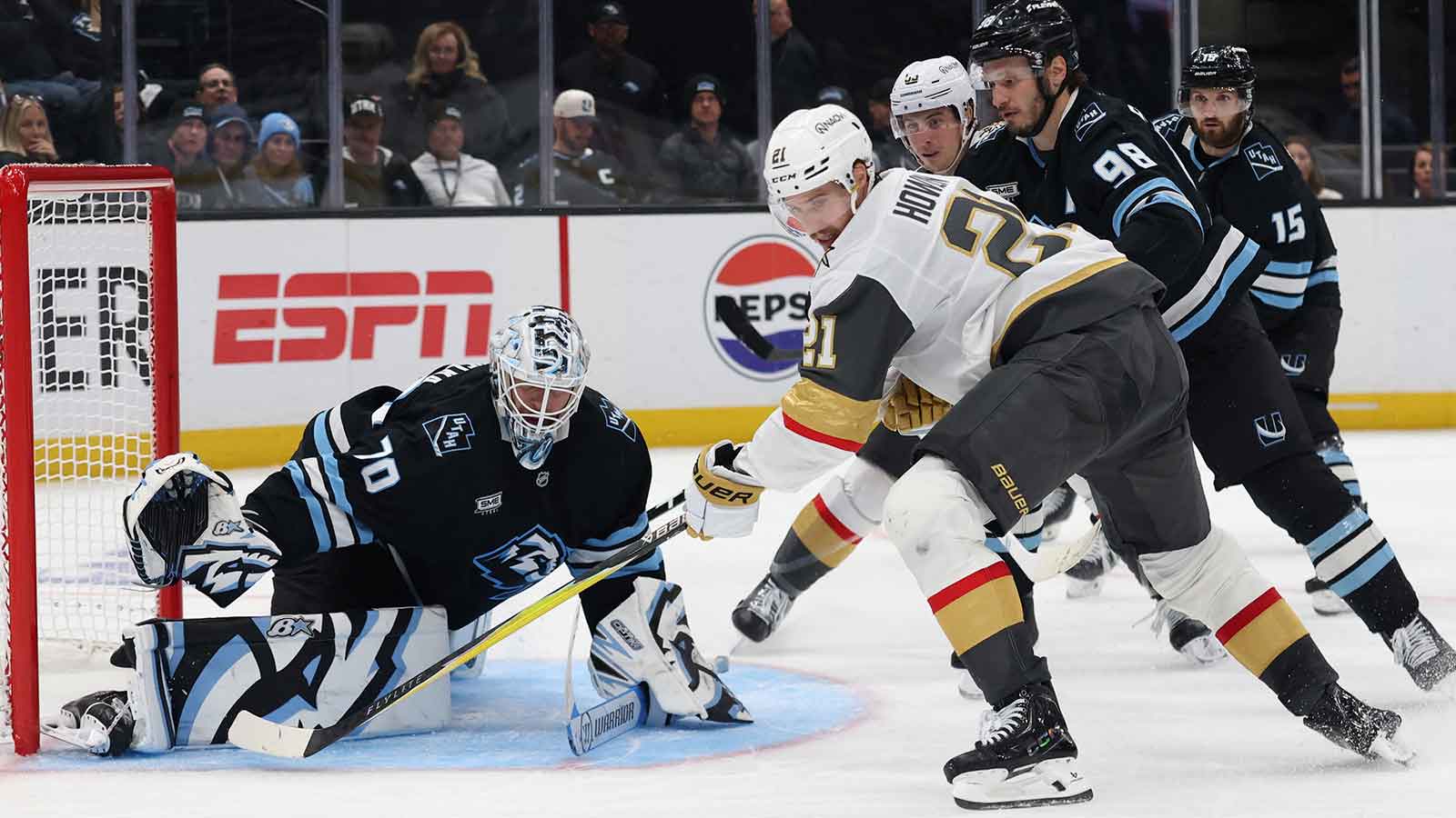 Vegas Golden Knights center Brett Howden (21) plays for the puck against Utah Mammoth goaltender Karel Vejmelka (70) and defenseman Mikhail Sergachev (98) during the third period in game six of the first round of the 2026 Stanley Cup Playoffs at Delta Center.