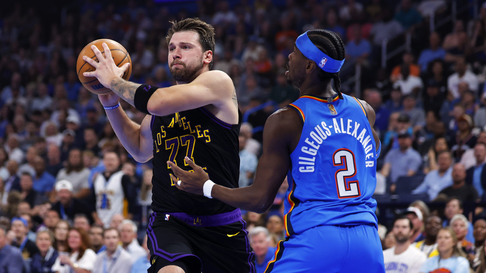 Lakers guard Luka Doncic (77) passes as Oklahoma City Thunder guard Shai Gilgeous-Alexander (2) defends during the first quarter at Paycom Center
