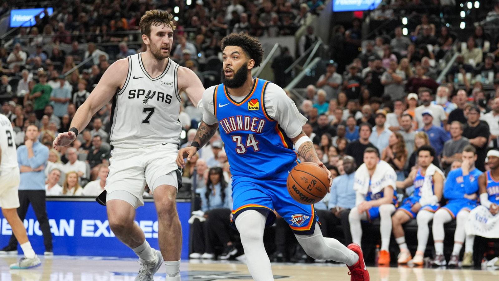 Oklahoma City Thunder forward Kenrich Williams (34) moves the ball while defended by San Antonio Spurs center Luke Kornet (7) in the fourth quarter during game four of the western conference finals for the 2026 NBA playoffs at Frost Bank Center. 