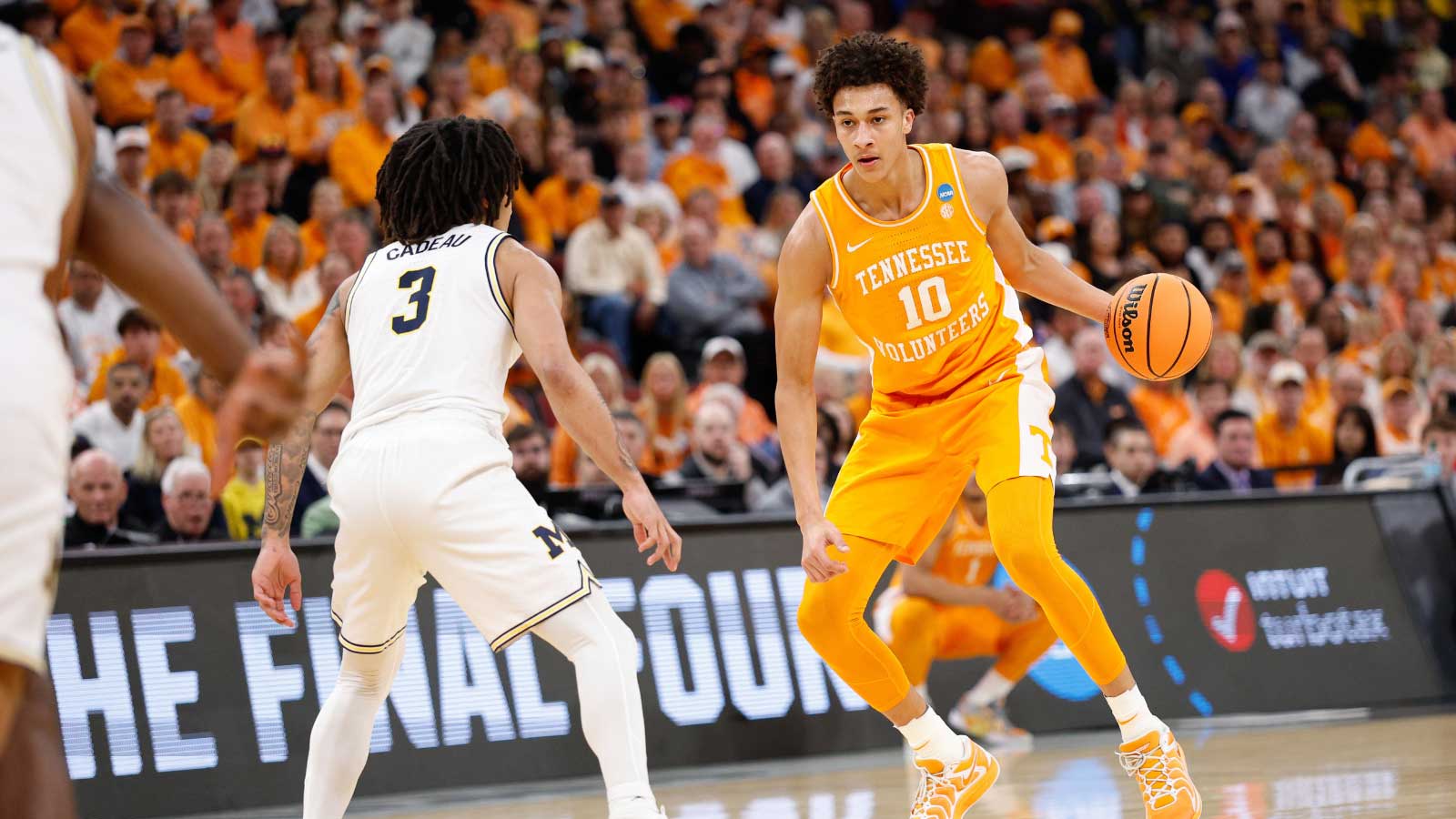 Tennessee Volunteers forward Nate Ament (10) moves the ball while defended by Michigan Wolverines guard Elliot Cadeau (3) in the first half during an Elite Eight game of the Midwest Regional of the men's 2026 NCAA Tournament at United Center. 