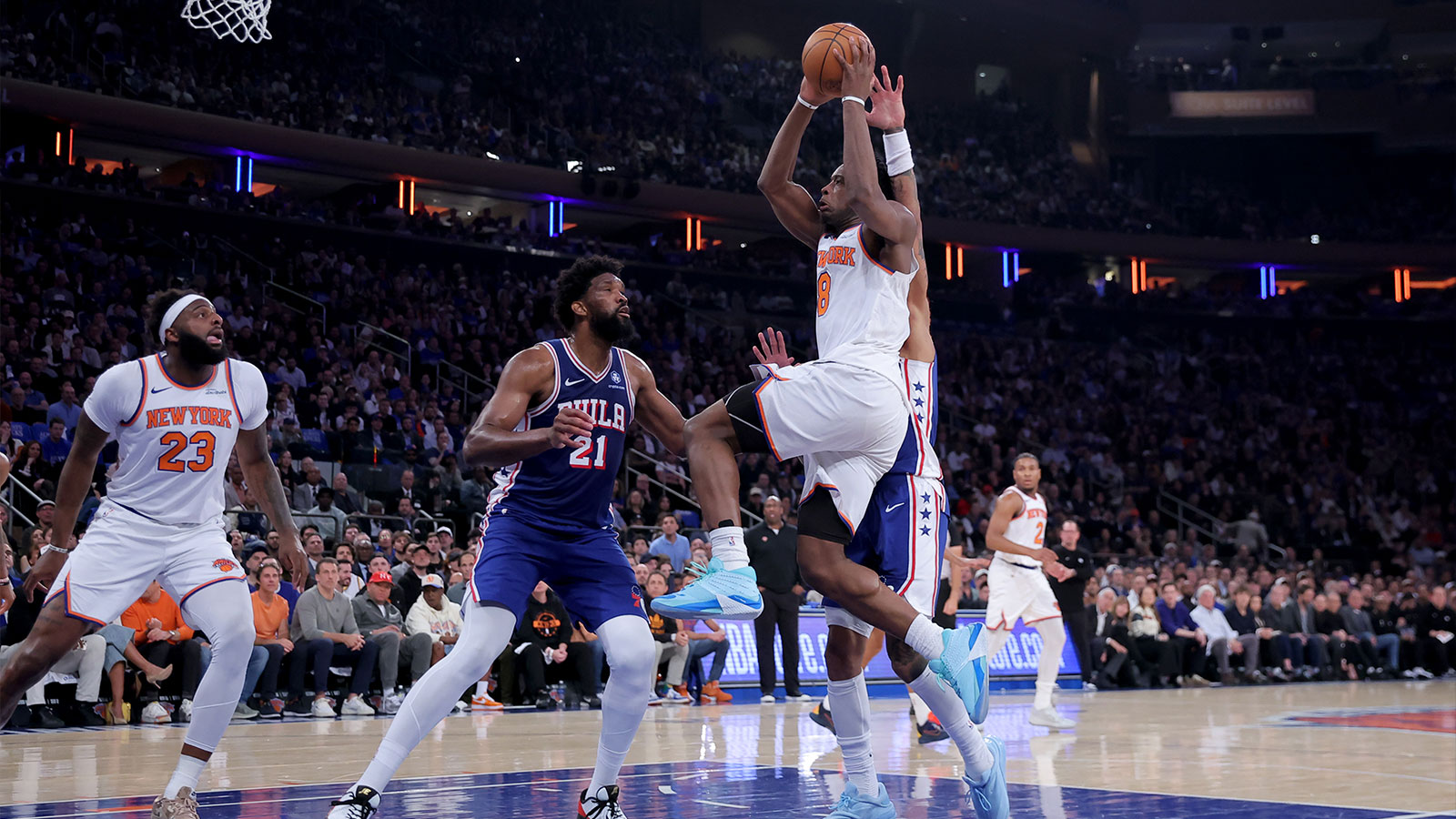 New York Knicks forward OG Anunoby (8) drives to the basket against Philadelphia 76ers center Joel Embiid (21) and forward Kelly Oubre Jr. (9) during the first quarter of game one of the eastern conference semifinal round of the 2026 NBA Playoffs at Madison Square Garden. 