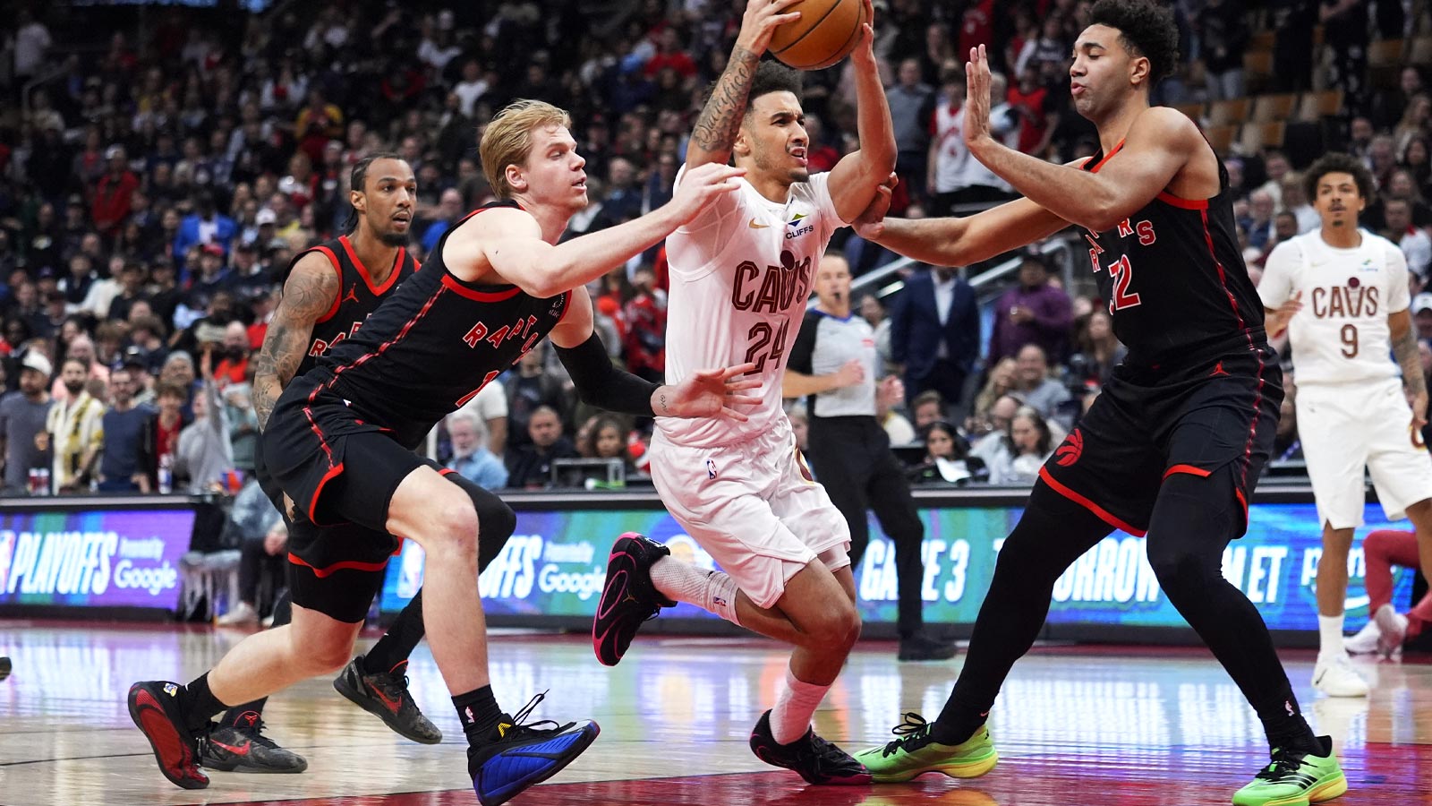 Cleveland Cavaliers guard Tyrese Proctor (24) drives to the basket against Toronto Raptors guard Gradey Dick (1) and forward Trayce Jackson-Davis (32) during the second half of game three of the first round of the 2026 NBA Playoffs at Scotiabank Arena.