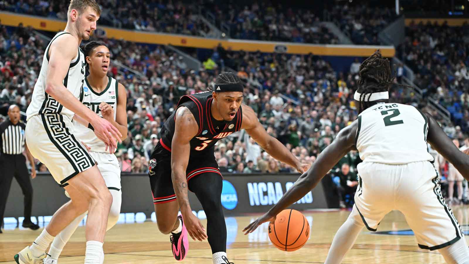 Louisville Cardinals guard Ryan Conwell (3) and Michigan State Spartans guard Kur Teng (2) scramble for a loose ball in the second half during a second round game of the men's 2026 NCAA Tournament at Keybank Center.
