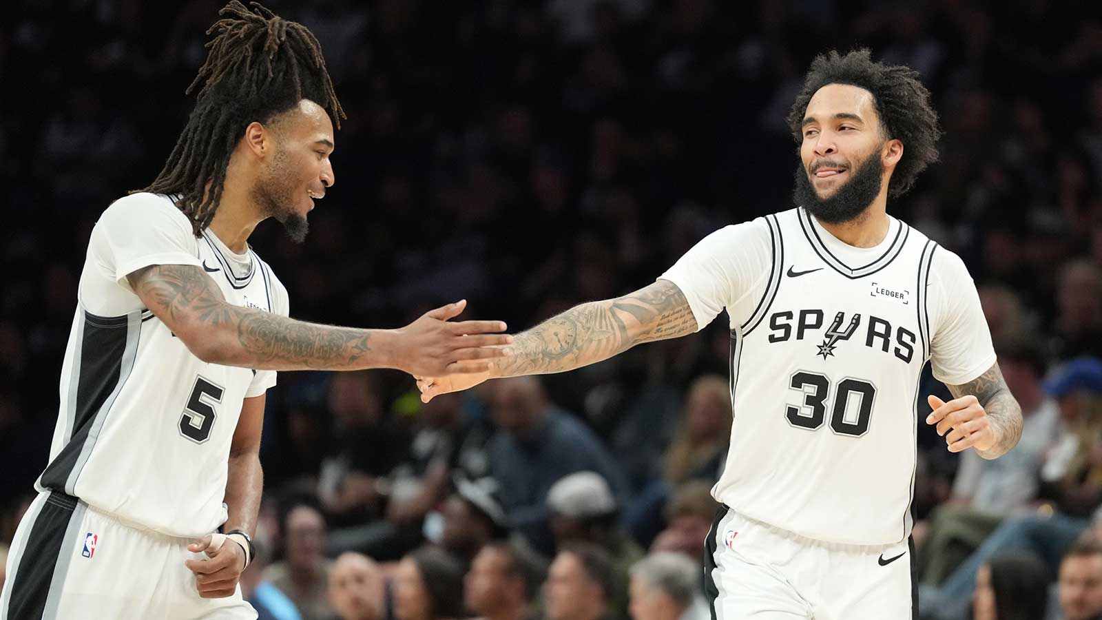Spurs forward Julian Champagnie (30) celebrates with guard Stephon Castle (5) in the second half against the Minnesota Timberwolves during game six of the second round of the 2026 NBA Playoffs at Target Center