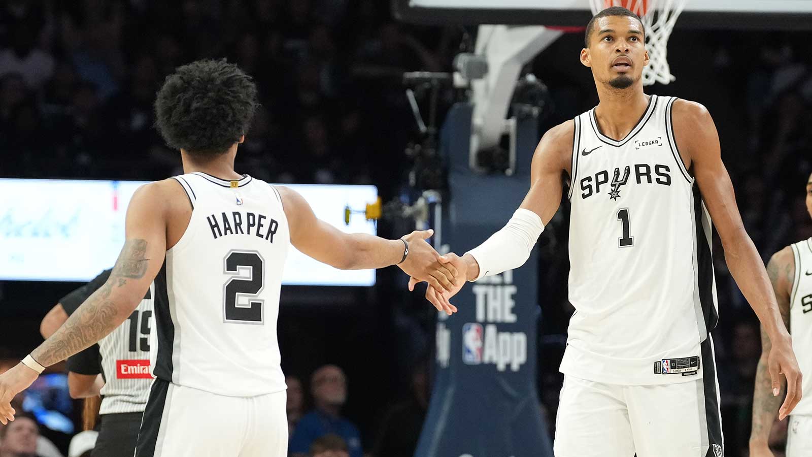 San Antonio Spurs forward Victor Wembanyama (1) shakes hands with San Antonio Spurs guard Dylan Harper (2) against the Minnesota Timberwolves in the second half during game six of the second round of the 2026 NBA Playoffs at Target Center.