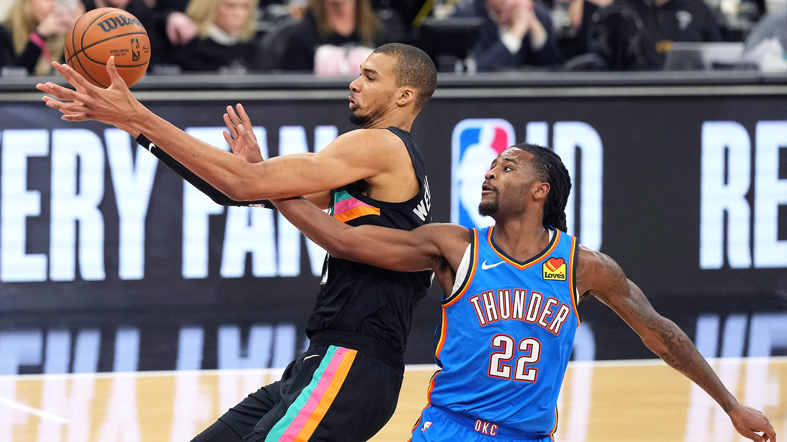 San Antonio Spurs forward Victor Wembanyama (1) and Oklahoma City Thunder guard Cason Wallace (22) battle for a loose ball during the first half at Frost Bank Center. 