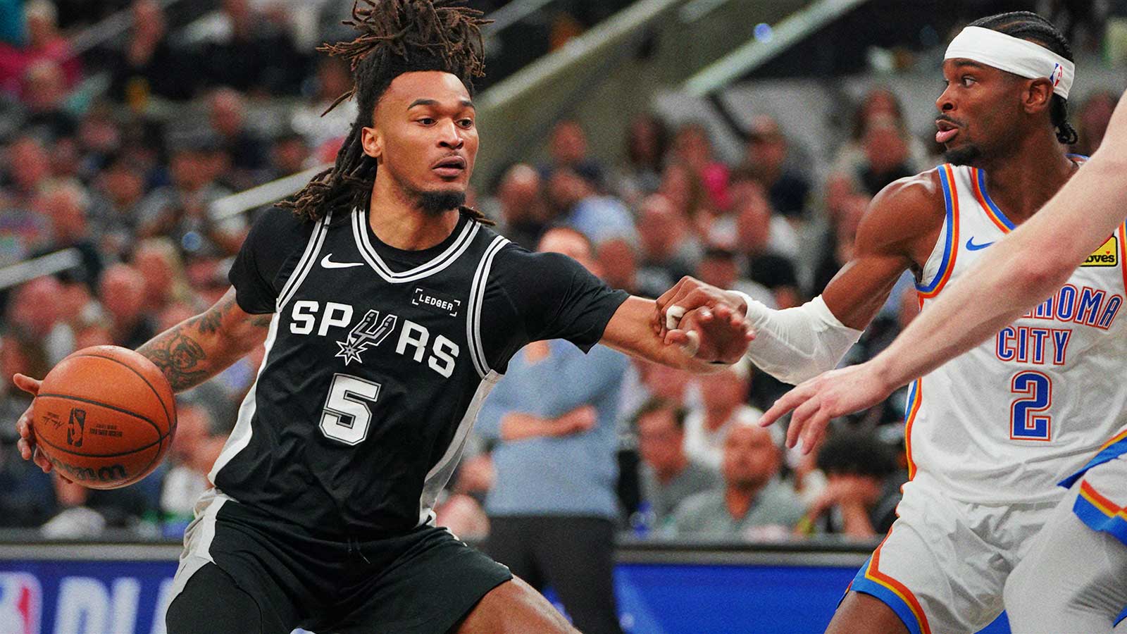 San Antonio Spurs guard Stephon Castle (5) dribbles the ball against Oklahoma City Thunder guard Shai Gilgeous-Alexander (2) in the first half during game six of the western conference finals for the 2026 NBA playoffs at Frost Bank Center.