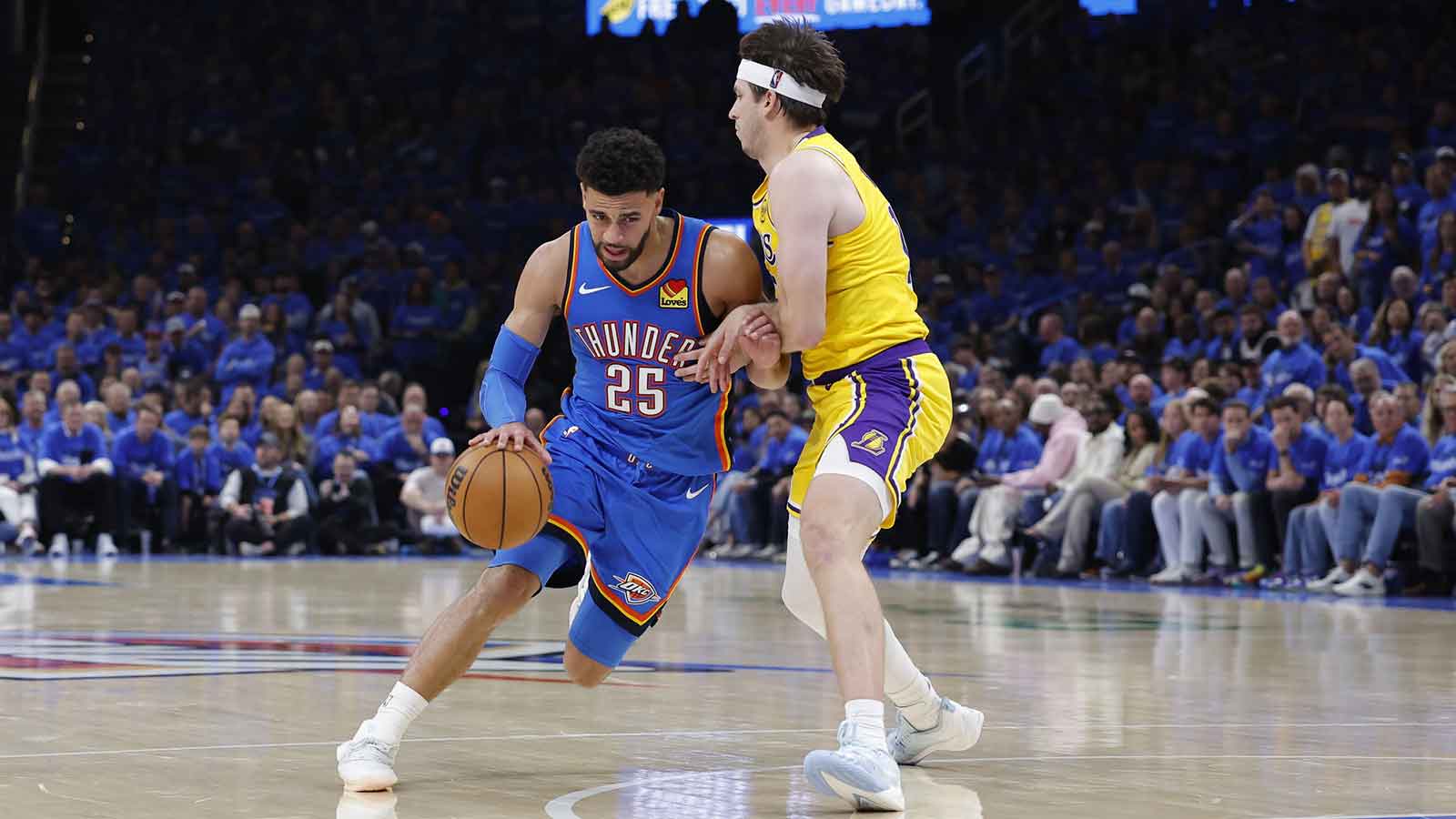 Thunder guard Ajay Mitchell (25) dribbles around Los Angeles Lakers guard Austin Reaves (15) in the second half during game one of the second round of the 2026 NBA Playoffs at Paycom Center