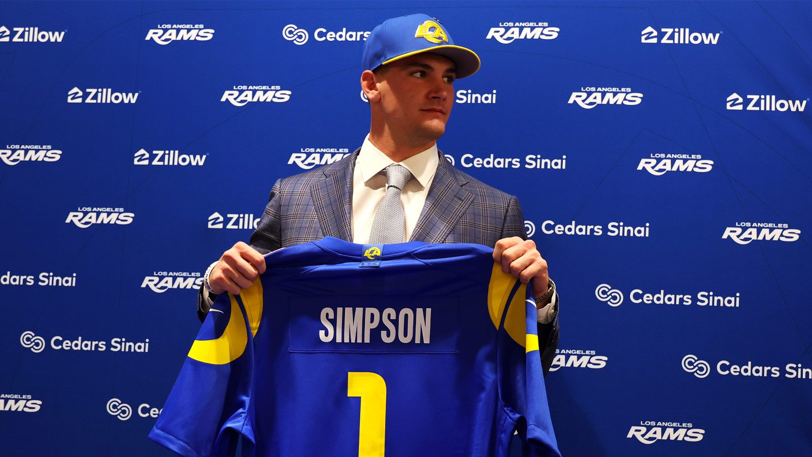 Los Angeles Rams first-round draft pick Ty Simpson poses with his jersey during a press conference at Code Next at Hollywood Park.