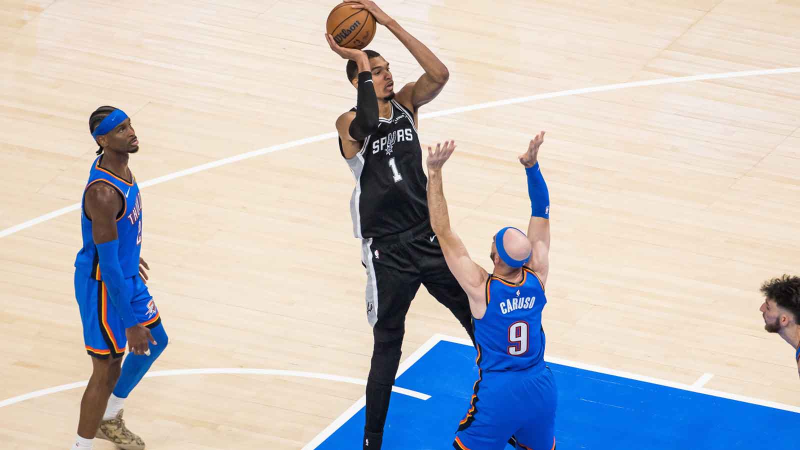 San Antonio Spurs center Victor Wembanyama (1) shoots while defended by Oklahoma City Thunder guard Alex Caruso (9) in the fourth quarter during game one of the western conference finals for the 2026 NBA playoffs at Paycom Center.