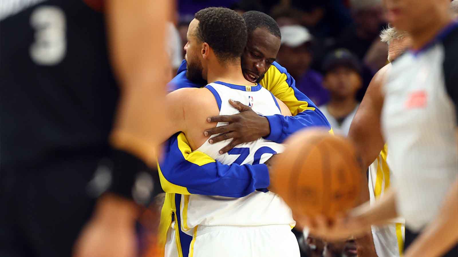 Warriors guard Stephen Curry (30) hugs forward Draymond Green against the Phoenix Suns during the closing seconds of the play-in rounds of the 2026 NBA Playoffs at Mortgage Matchup Center
