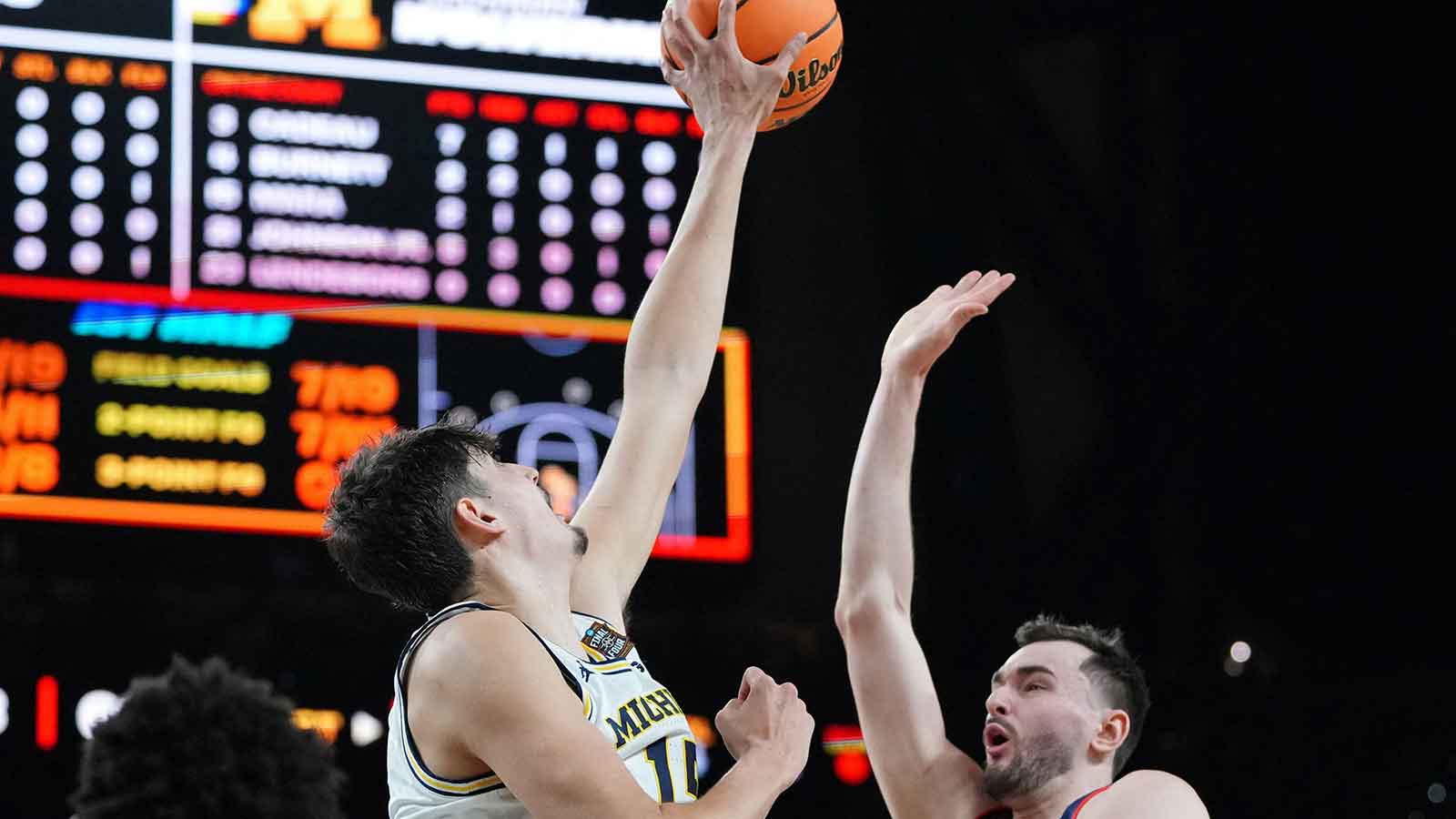 Michigan Wolverines center Aday Mara (15) blocks the shot of UConn Huskies forward Alex Karaban (11) during the first half in the national championship of the Final Four of the men's 2026 NCAA Tournament between the and the Michigan Wolverines at Lucas Oil Stadium. 