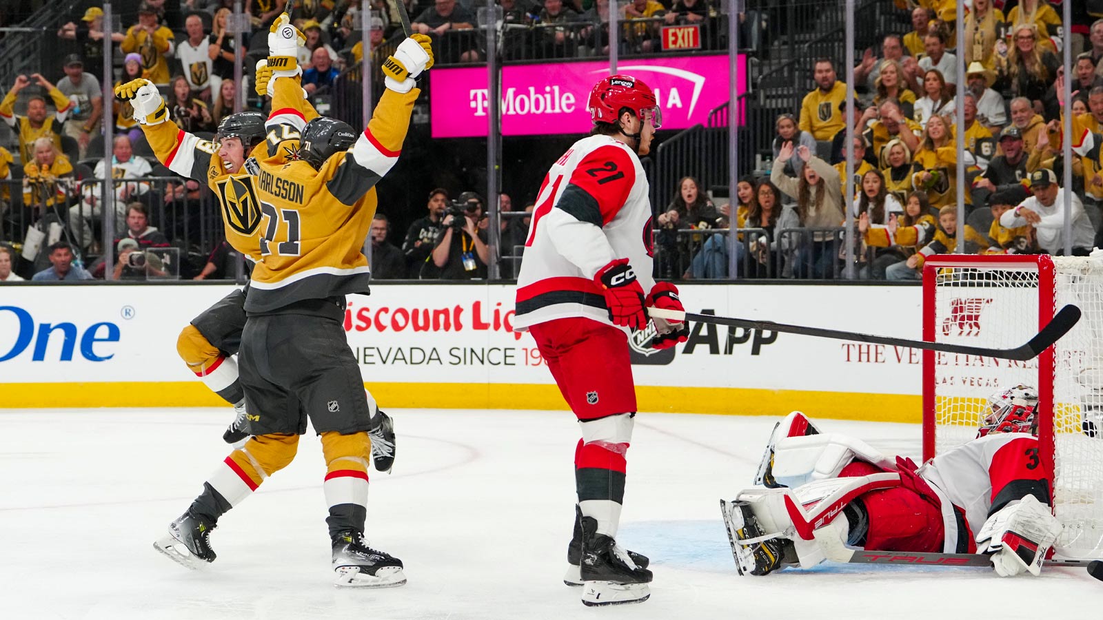 Vegas Golden Knights right wing Mitch Marner (93) and center William Karlsson (71) celebrate after a goal by defenseman Shea Theodore (not pictured) as Carolina Hurricanes defenseman Alexander Nikishin (21) and goaltender Brandon Bussi (32) react during the second overtime in game three of the 2026 Stanley Cup Final at T-Mobile Arena.