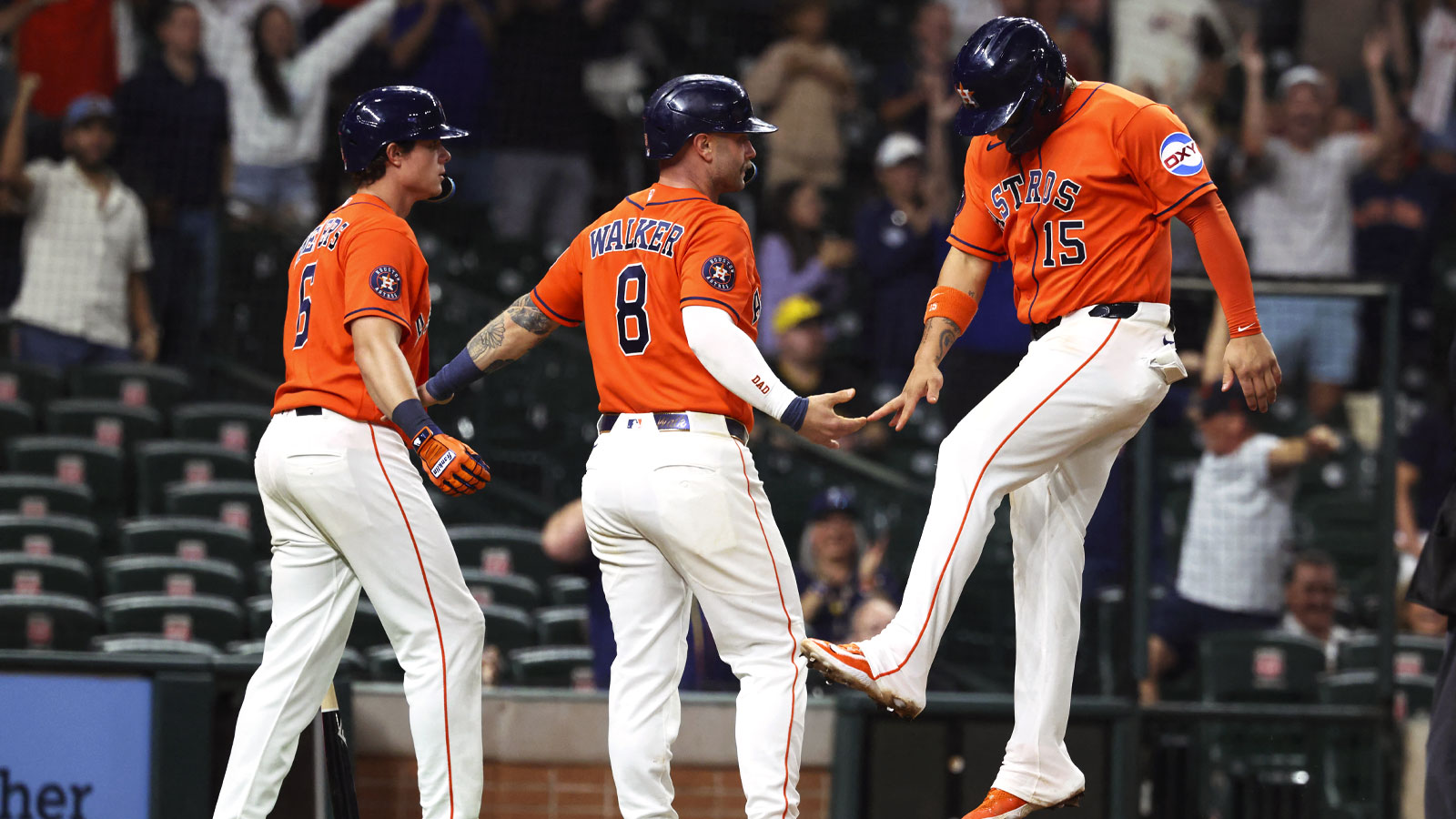 Houston Astros third baseman Isaac Paredes (15) celebrates with first baseman Christian Walker (8) and center fielder Jake Meyers (6) after scoring a run during the eighth inning against the Pittsburgh Pirates at Daikin Park.