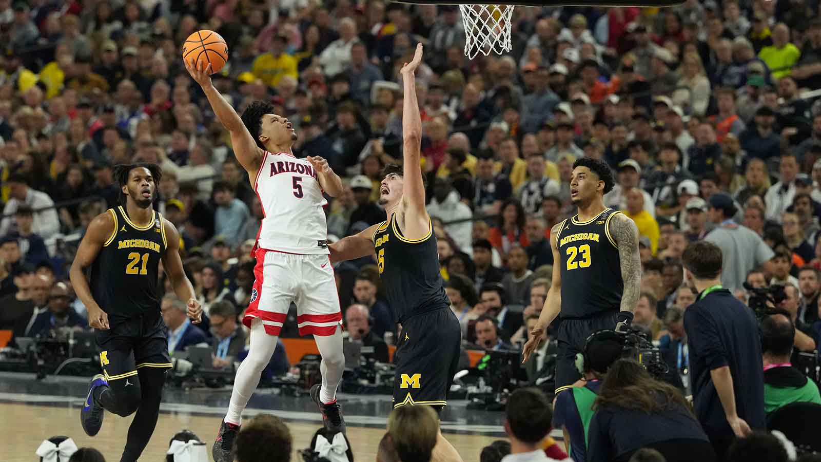 Arizona Wildcats guard Brayden Burries (5) shoots against Michigan Wolverines center Aday Mara (15) in the second half during a semifinal of the Final Four of the men's 2026 NCAA Tournament at Lucas Oil Stadium.