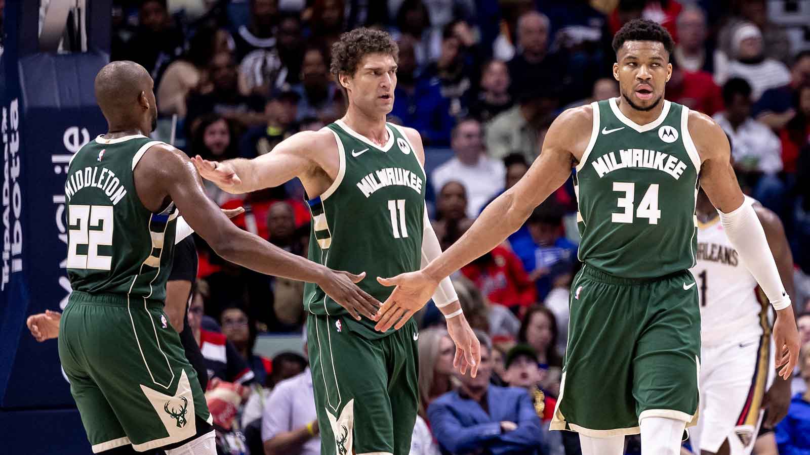 Bucks forward Giannis Antetokounmpo (34) slaps hands with forward Khris Middleton (22) and center Brook Lopez (11) after a play against the New Orleans Pelicans during the second half at Smoothie King Center