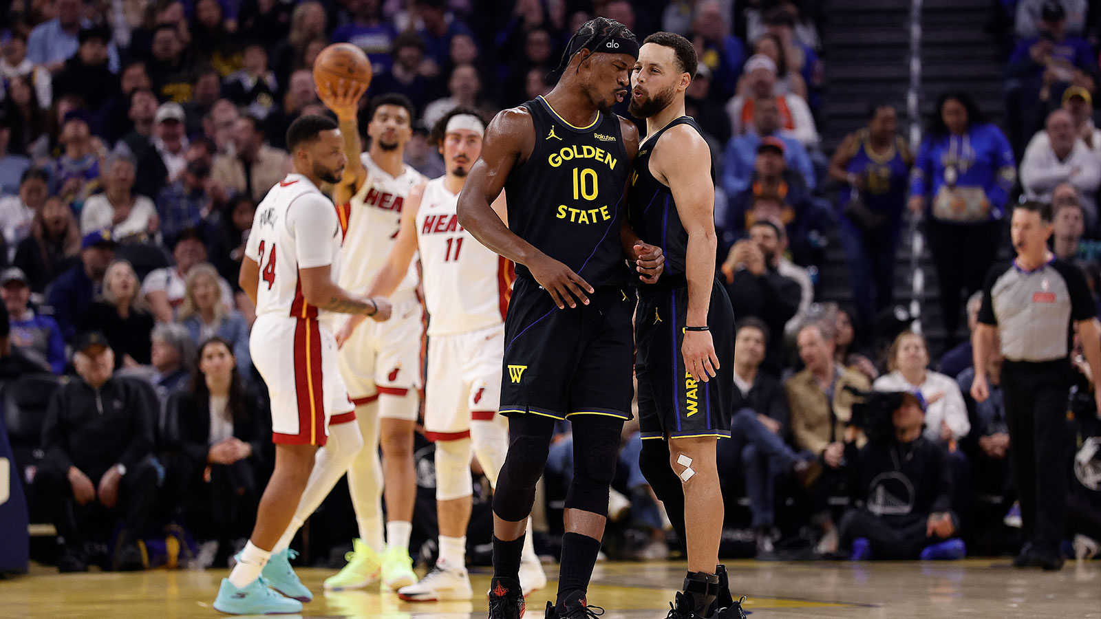 Golden State Warriors forward Jimmy Butler III (10) and guard Stephen Curry (30) react after Butler misses a shot at the buzzer during the first quarter against the Miami Heat at Chase Center.