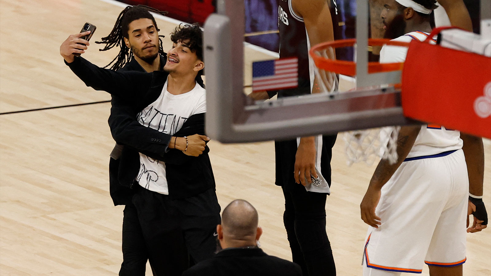 Fan who ran on court during New York Knicks-San Antonio Spurs Game 1 of the NBA Finals with Victor Wembanyama (Wemby) and Mitchell Robinson.