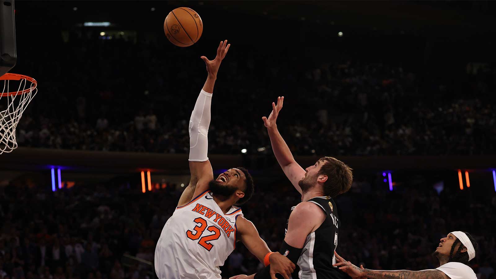 New York Knicks center Karl-Anthony Towns (32) reaches for a rebound in front of San Antonio Spurs center Luke Kornet (7) during game three of the 2026 NBA Finals at Madison Square Garden.