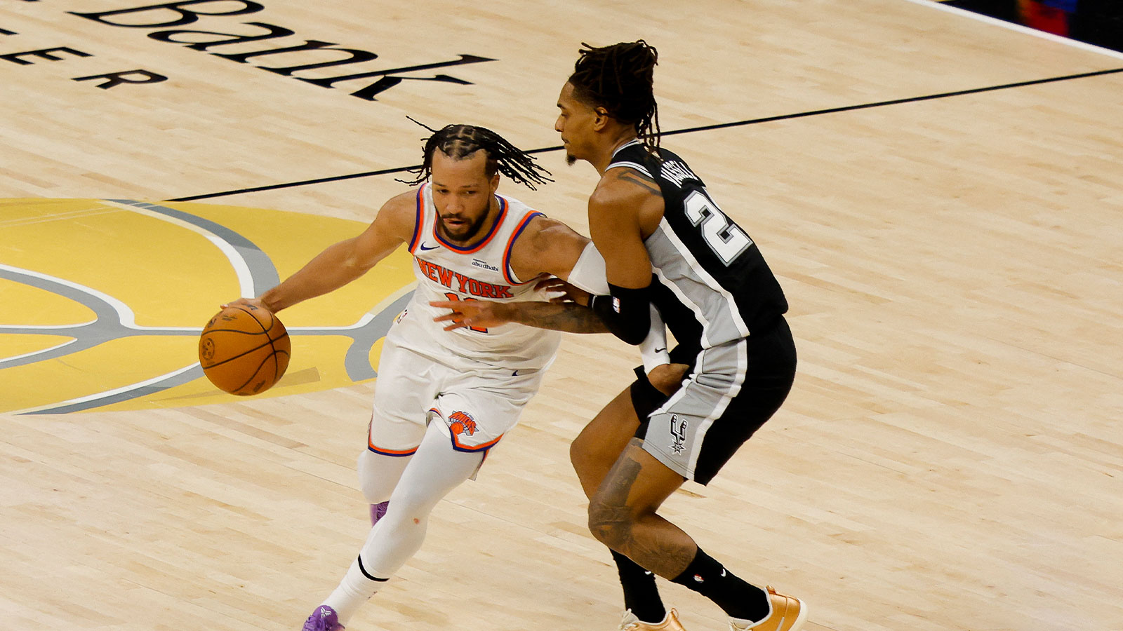 Knicks guard Jalen Brunson (11) moves the ball past San Antonio Spurs guard Devin Vassell (24) during the second quarter during game one of the 2026 NBA Finals at Frost Bank Center