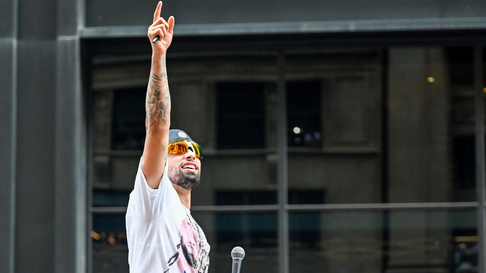 Knicks guard Jose Alvarado points to fans in a building during the New York Knicks Championship Parade through the Canyon of Heroes